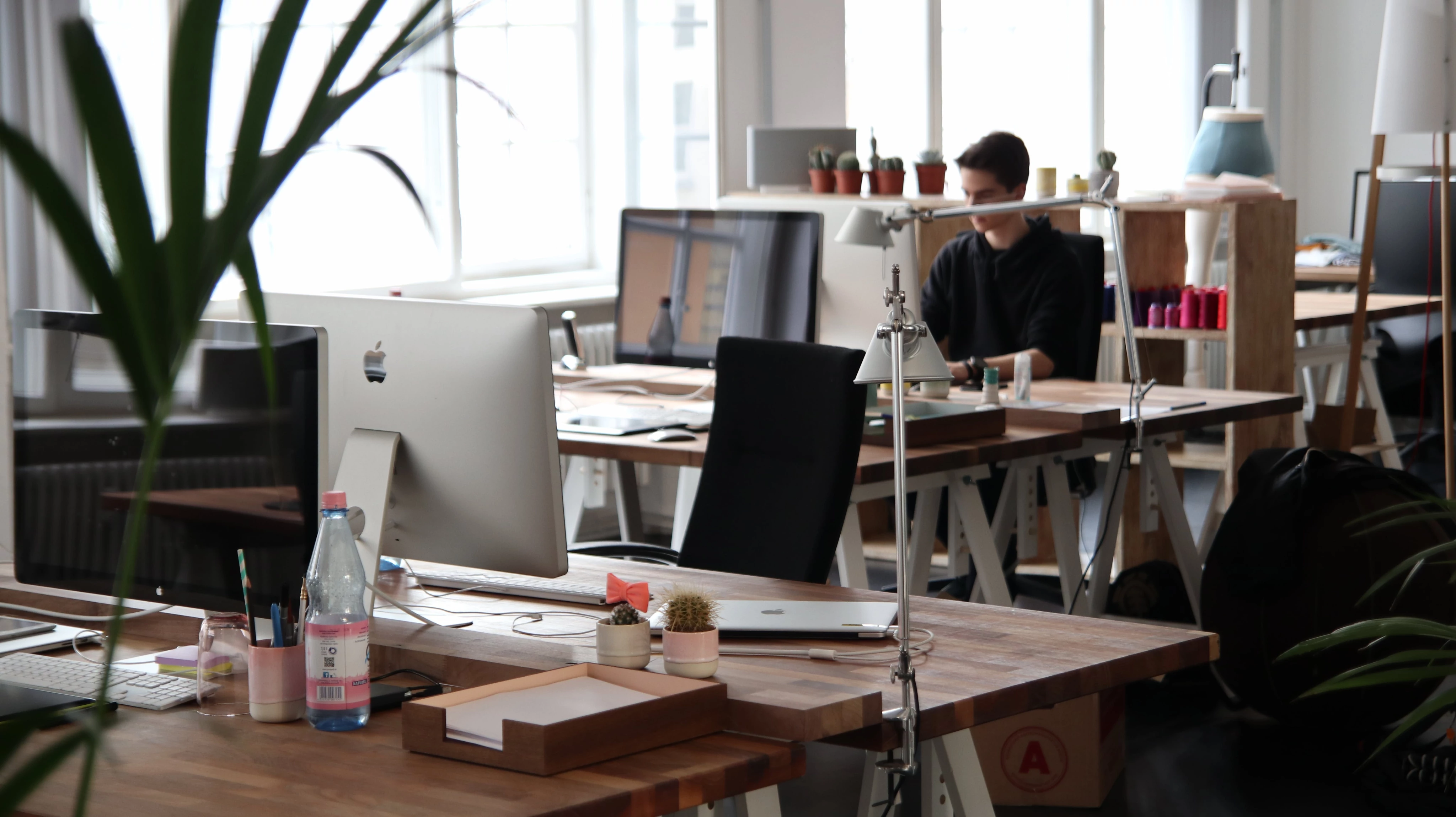 Open office with desks, computers, and a person working.